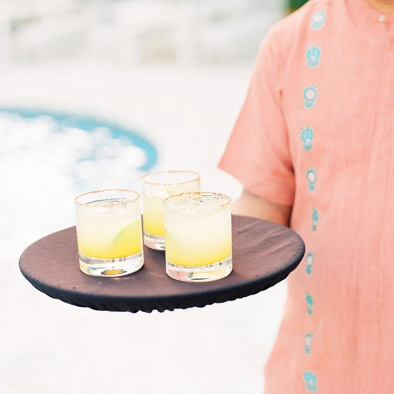 Person holding drinks on a tray