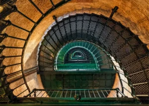 An overhead shot of a metal spiral staircase in a circular brick stariwell