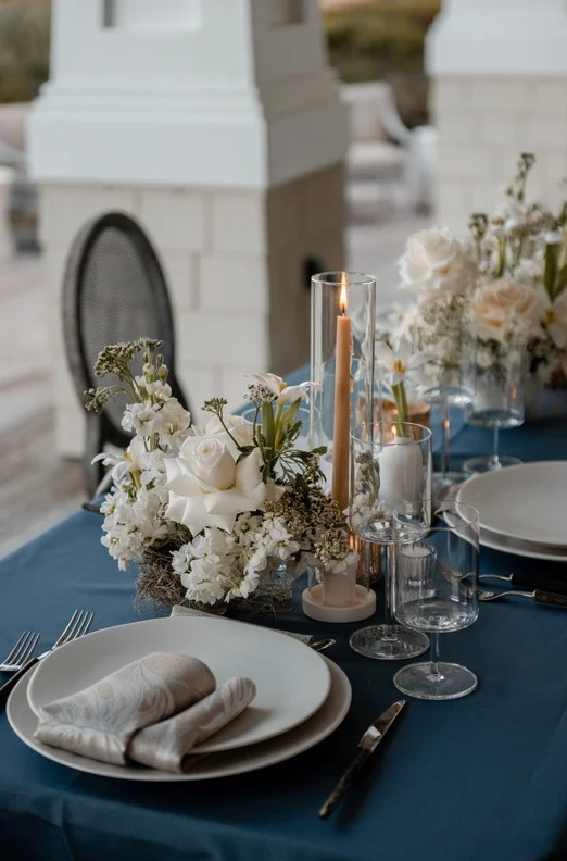 Elegant dining setting with plates. silverware, candles, and floral arrangements