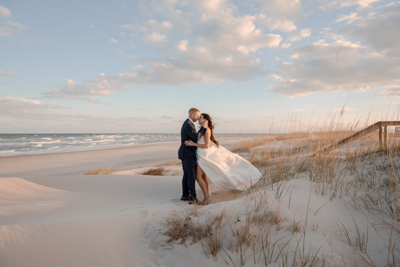Newlywed bride and groom embracing on the beach
